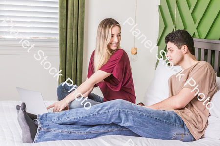 A young couple sitting in bed stock photo with image ID: 9e0dbd26-bd7f-4002-893c-f4d7a01b2355