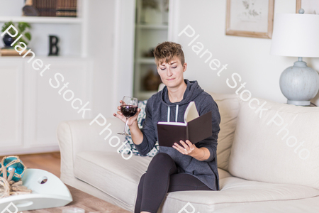 A young lady sitting on the couch stock photo with image ID: a0042170-2c55-4cd2-96ef-705c0da96b36