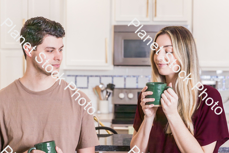 A young couple sitting and enjoying hot drinks stock photo with image ID: a3aa2618-9276-4874-ab49-e75c29350a7c