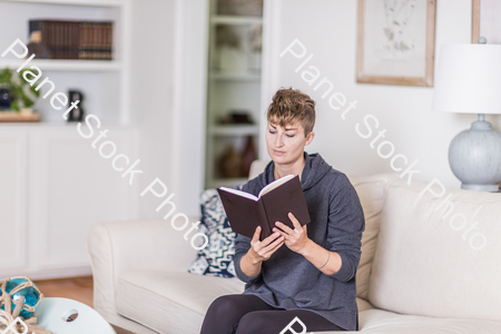 A young lady sitting on the couch stock photo with image ID: a3b1324e-4256-4ada-8653-68b94efba9c2