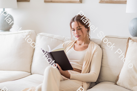 A young lady sitting on the couch stock photo with image ID: ad96e536-ed72-4d79-bf69-c3d9194c903c