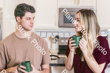 A young couple sitting and enjoying hot drinks stock photo with image ID: af9d6f8d-833d-4028-97a9-f9baa0005c45
