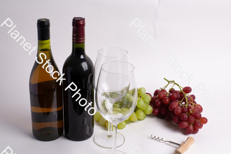Two bottles of wine, with corkscrew, grapes, and wine glasses stock photo with image ID: b036c1c0-f414-4fa4-af7b-20be0d7e516f