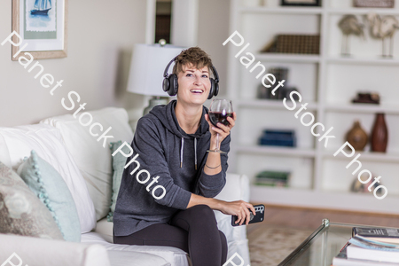 A young lady sitting on the couch stock photo with image ID: b32c7a7b-dae5-4c60-9122-a75c806bc130