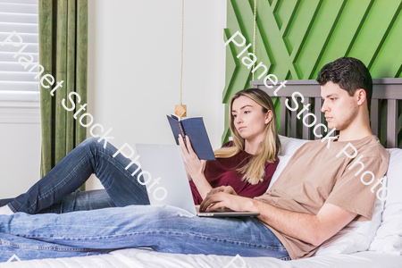 A young couple sitting in bed stock photo with image ID: b5454d01-7e1b-41ed-adf2-ef952978bc4d