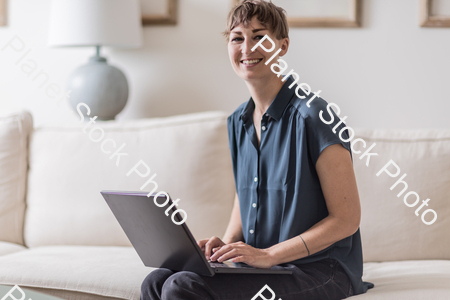 A young lady sitting on the couch stock photo with image ID: bc4e569c-5afd-41af-99aa-4b7566803fe6