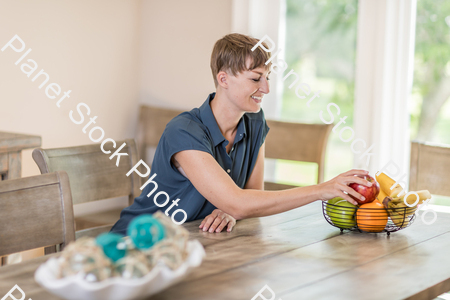 A young lady grabbing fruit stock photo with image ID: bcdc83d5-6833-4490-94c9-6d04f523329f
