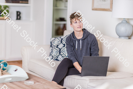 A young lady sitting on the couch stock photo with image ID: bd92b16d-b544-4352-a886-a81200da420d