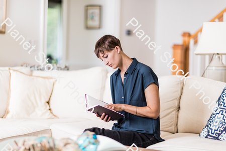 A young lady sitting on the couch stock photo with image ID: c06f234d-7cf7-45aa-9ec1-3502b0eaedcf