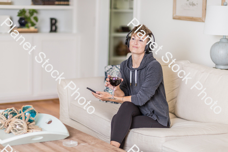 A young lady sitting on the couch stock photo with image ID: c15ee90d-411e-4312-8eba-737498bf2716