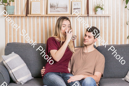 A young couple cozying up on the couch stock photo with image ID: c312433b-9b22-4551-9389-36f7c76dbcc8