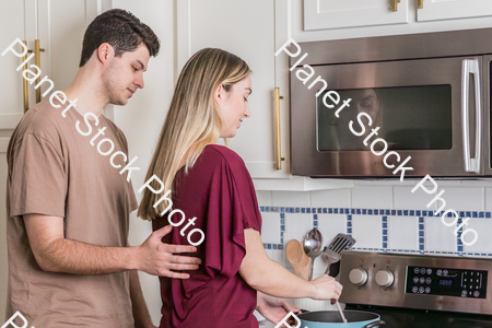 A young couple preparing a meal in the  kitchen stock photo with image ID: c486030b-ed93-4c21-aafa-23e7f930da98