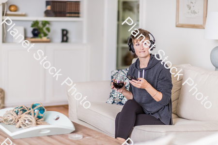 A young lady sitting on the couch stock photo with image ID: c4a1c433-5f66-40cb-82f2-21e4777b34f0