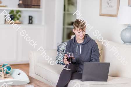 A young lady sitting on the couch stock photo with image ID: cc6a9c45-7e82-4e4a-bad9-2ecd627ebb4e
