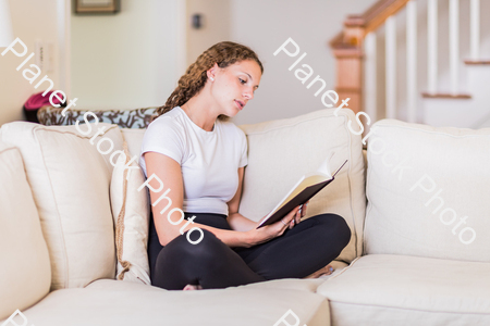 A young lady sitting on the couch stock photo with image ID: ce803b1b-7d95-480d-b102-5a0a71c97ff6