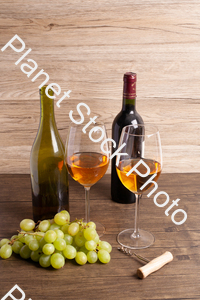 Two bottles of wine, with corkscrew, grapes, and wine glasses stock photo with image ID: d29f06b0-4818-4308-9e67-5056166b6930