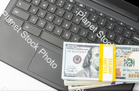 Three stacks of dollar bills on a laptop computer stock photo with image ID: d77bf3f6-ac8c-400f-bd0b-1d29a75b6c85