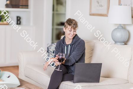 A young lady sitting on the couch stock photo with image ID: db31a3b2-dbef-4cbc-8feb-366a1d1442e0