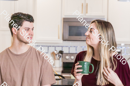 A young couple sitting and enjoying hot drinks stock photo with image ID: dcd4c037-0db4-435e-9c86-2a4cda86fd55