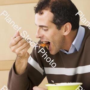 A Man Eating Food stock photo with image ID: de7d9339-9476-4ec4-aaaa-d602ccc40be1