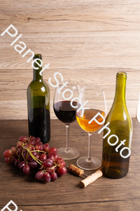 Two bottles of wine, with corkscrew, grapes, and wine glasses stock photo with image ID: df85d67f-8e6f-4015-9312-8bc5f9e1766e