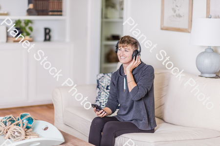 A young lady sitting on the couch stock photo with image ID: e17e80ce-13d4-4569-85a5-9fdd1a2df9c9