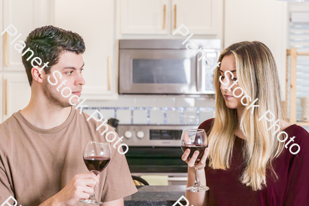 A young couple sitting and enjoying red wine stock photo with image ID: e393a3ac-5781-4e9d-8fc8-0b155fba7be4