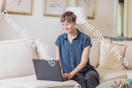 A young lady sitting on the couch stock photo with image ID: e9a4f3dd-461a-4c7e-8254-c8d16f5016c7