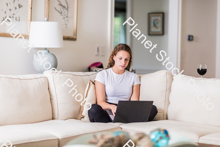 A young lady sitting on the couch stock photo with image ID: eddc6084-def2-457e-9a83-9988d4835bc5
