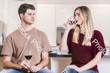 A young couple sitting and enjoying red wine stock photo with image ID: ee0ccc19-16c2-480d-b291-118fbc7e3228