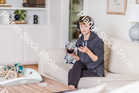 A young lady sitting on the couch stock photo with image ID: ef9c0a8a-8ad0-492e-bacd-cfb2702549c4