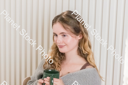 A girl sitting and enjoying a hot drink stock photo with image ID: f6fbb464-1df1-4a18-8d25-c86c6dcb7300