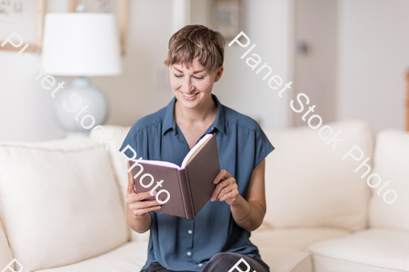 A young lady sitting on the couch stock photo with image ID: fda073ab-a9d5-439b-84c9-f5ac3d03193a