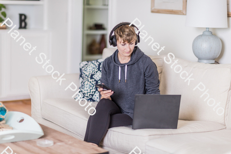A young lady sitting on the couch stock photo with image ID: fe3f649c-6707-4430-8e33-bad1d1af5edd