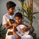 A Boy Name with Meher on His White Tshirt in Black Letters and a Girl Sits Side to Him and Wears a Sari of Colour Black and Having a Pussy in Hand