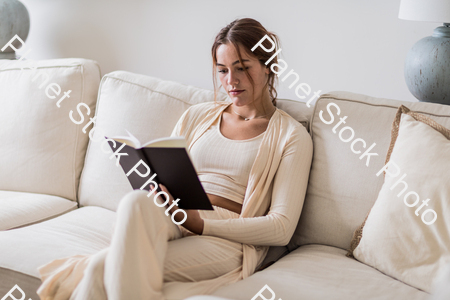 A young lady sitting on the couch stock photo with image ID: 7d51a7cb-f7c4-42b3-a0c5-a81a3e5062dd