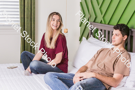 A young couple sitting in bed stock photo with image ID: a32dc131-a8df-4f0e-8557-5bfd6a084377