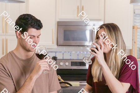 A young couple sitting and enjoying red wine stock photo with image ID: fa4bd1dc-8f21-4ccc-be90-ced11d97b738