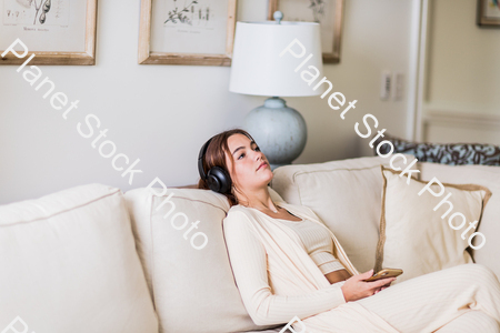 A young lady sitting on the couch stock photo with image ID: 9fc8a955-8b9f-41cb-9be0-59b8edae15dd