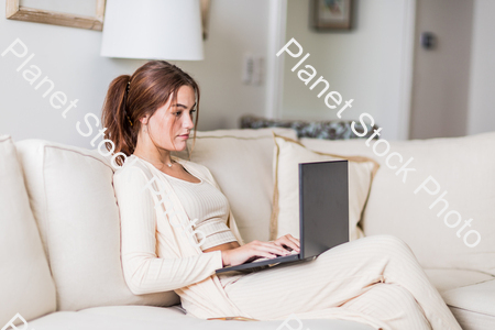 A young lady sitting on the couch stock photo with image ID: 91a39275-6958-47c8-89fa-ddf4b19fc85e