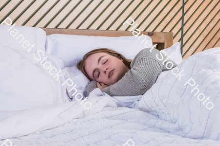A girl sleeping in bed stock photo with image ID: a13050d7-ba00-47a6-a714-bc625fae1894