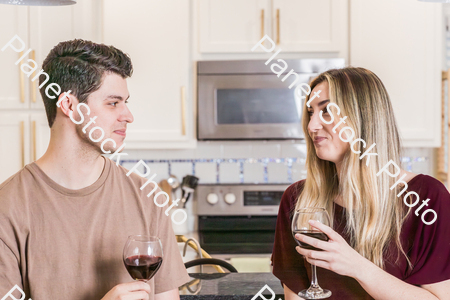 A young couple sitting and enjoying red wine stock photo with image ID: 42e4735b-02ff-4c9c-a35e-9e96be5066ce