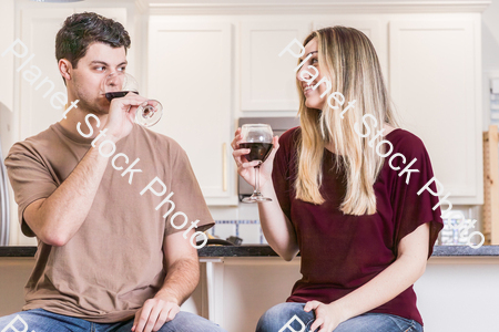 A young couple sitting and enjoying red wine stock photo with image ID: a52f3bf6-469a-4779-84a7-add750e5d29c