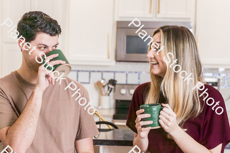 A young couple sitting, and enjoying hot drinks stock photo with image ID: af062f73-933b-4c8b-9171-5f7501bcbd58