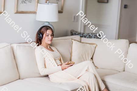 A young lady sitting on the couch stock photo with image ID: c9b29517-c1ef-4933-b4c1-1fcd86338eaa
