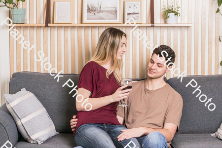 A young couple cozying up on the couch stock photo with image ID: 0102580d-e15e-4889-b0a9-f52af6e00a0c