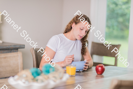 A young lady having a healthy breakfast stock photo with image ID: 24ed05d2-7601-4e79-9940-ec9ed6ccda3c