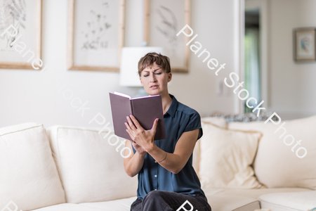 A young lady sitting on the couch stock photo with image ID: 21727e14-4f8e-4423-a8e7-d564da25f160