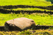 A large rock or boulder on a grass field.