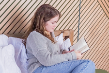 A girl reading a book in bed